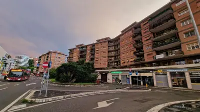 a bus driving down a city street with tall buildings at Casa Vista San Pietro in Rome