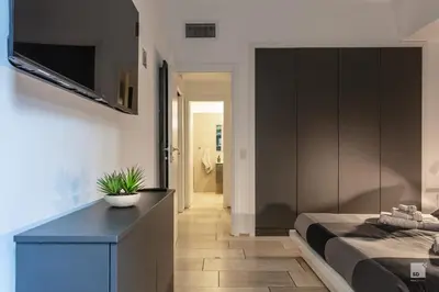 a bedroom with a bed and a tv on a wall at Luxury House in Roma Nicolo V 120 mq in Rome