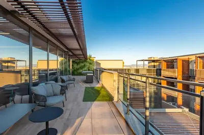 a balcony with chairs and tables on a building at AureaLiving - Sage luxury apt with Air Conditioning, Fast Wifi and free Gym in Rome