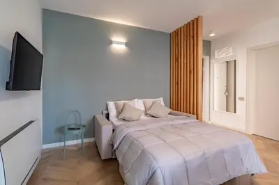 a white bedroom with a bed and a television at AureaLiving - Sage luxury apt with Air Conditioning, Fast Wifi and free Gym in Rome