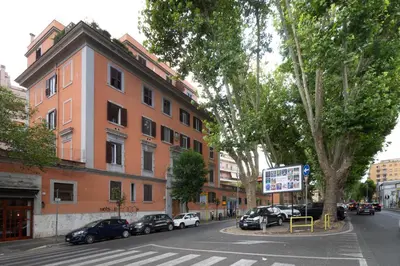 a street with cars parked in front of a building at NOH Vatican Courtyard in Rome