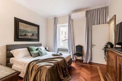 a bedroom with a bed and a large window at The Best Rent - One-bedroom apartment in a quiet, classically styled corner near the Quirinale in Rome