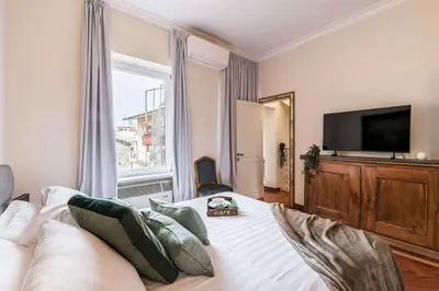 a bedroom with a large bed with a large window at The Best Rent - One-bedroom apartment in a quiet, classically styled corner near the Quirinale in Rome