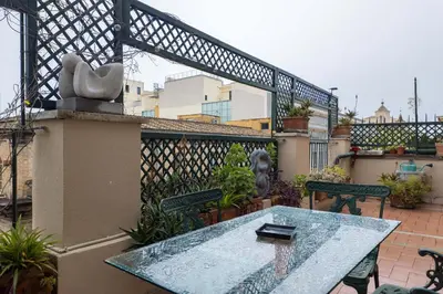 a patio with a table and benches on a balcony at The Best Rent - One-bedroom apartment in a quiet, classically styled corner near the Quirinale in Rome