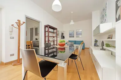 a dining room and living room with a glass table and chairs at YCH-Nice flat with patio near Vatican in Rome
