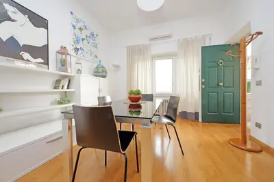 a dining room with a table and chairs and a green door at YCH-Nice flat with patio near Vatican in Rome
