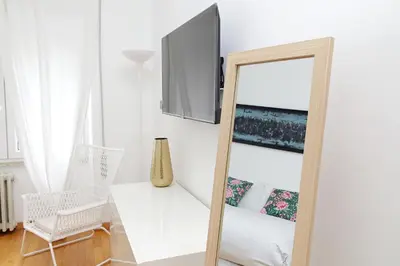a mirror in a white room with a chair and a table at YCH-Nice flat with patio near Vatican in Rome