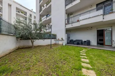 a courtyard in a building with a tree in the grass at Primavera Home in Rome