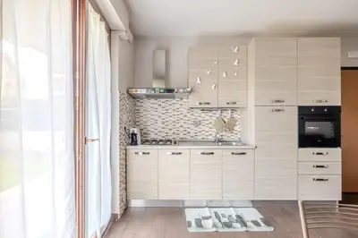 a kitchen with white cabinets and a sink at Primavera Home in Rome