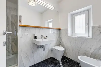 a bathroom with a sink and a toilet and a window at Vivilo Collection - Loft Santo Spirito in Rome