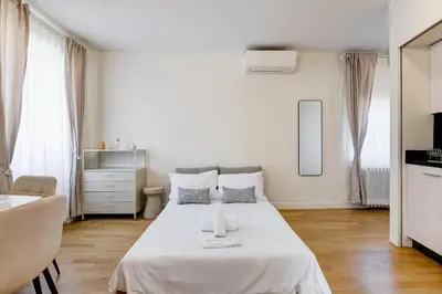 a white bedroom with a bed and a dresser at Vivilo Collection - Loft Santo Spirito in Rome
