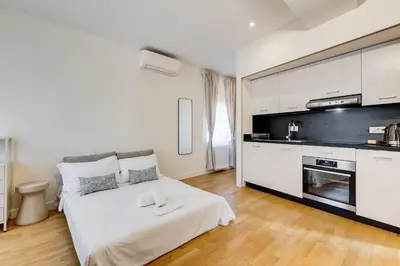 a white room with a bed and a kitchen at Vivilo Collection - Loft Santo Spirito in Rome