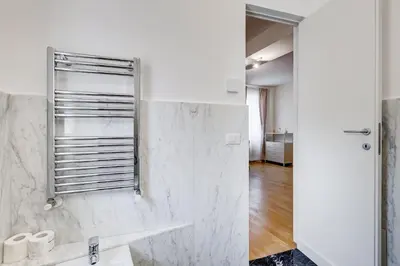 a white bathroom with a sink and a mirror at Vivilo Collection - Loft Santo Spirito in Rome