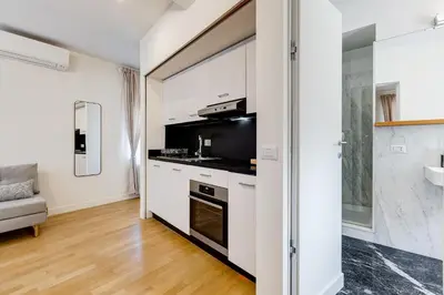 a kitchen with white cabinets and a large window at Vivilo Collection - Loft Santo Spirito in Rome