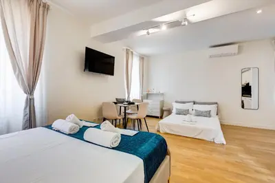 a bedroom with two beds and a table in it at Vivilo Collection - Loft Santo Spirito in Rome