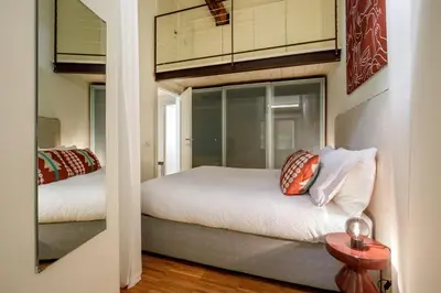 a small bedroom with two beds and a mirror at Liberti Colosseo - Luxury Apartment in Rome