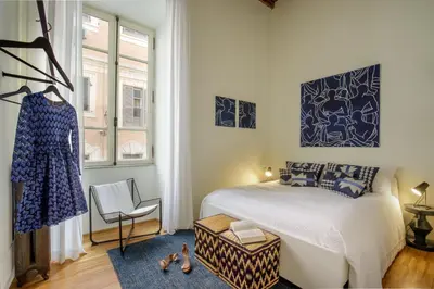 a bedroom with a bed and a chair and a window at Liberti Colosseo - Luxury Apartment in Rome