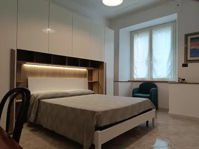 a bedroom with a bed and a blue chair at Aldo in Rome