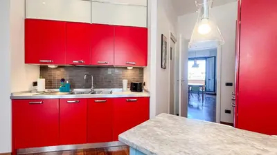 a red kitchen with a sink and red cabinets at La Casa di Livietta in Rome