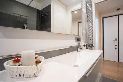 a white bathroom with a sink and a mirror at Pgrhome Giulio Cesare in Rome