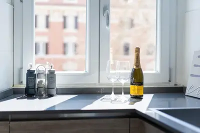 a bottle of champagne and two glasses on a kitchen counter at Pgrhome Giulio Cesare in Rome