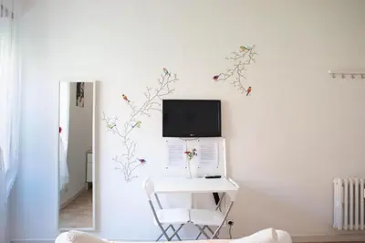 a room with a desk with a computer on a wall at Cozy Piramide Rooms in Rome