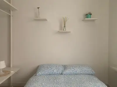 a bedroom with a bed and two shelves on the wall at Cozy Piramide Rooms in Rome
