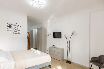a white bedroom with a bed and a tv at La Dolce Vita in Rome