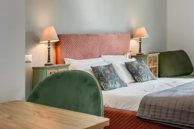 a bedroom with a bed and a table and two lamps at Amor Rome Apartment & Suites in Rome