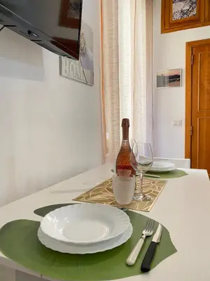 a table with a plate and a bottle of wine at Easy Suite Roma San Pietro in Rome