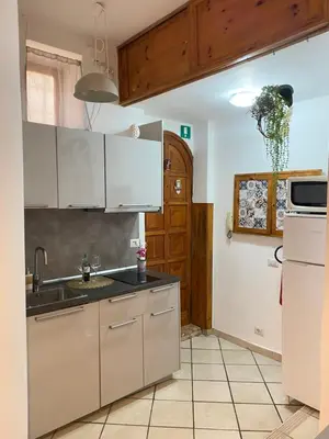 a kitchen with white cabinets and a sink at Easy Suite Roma San Pietro in Rome