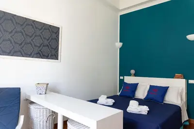 a bedroom with a bed with a blue wall at Residenza Romana in Rome