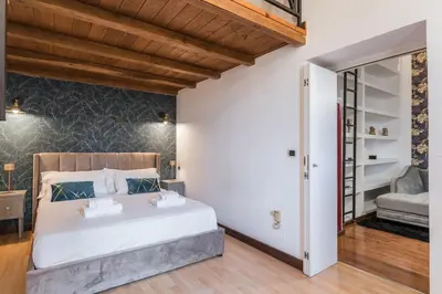 a bedroom with a large white bed and a mirror at Vatican Duplex, perfect for visiting Rome in Rome