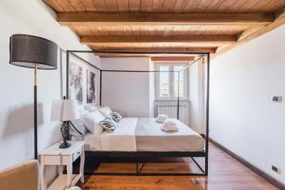 a bedroom with a bed and a lamp on a wooden floor at Vatican Duplex, perfect for visiting Rome in Rome