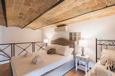 a bedroom with two beds and a brick wall at Vatican Duplex, perfect for visiting Rome in Rome