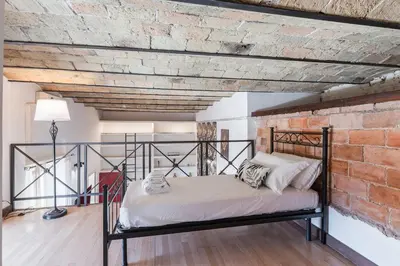 a bed in a room with a brick wall at Vatican Duplex, perfect for visiting Rome in Rome