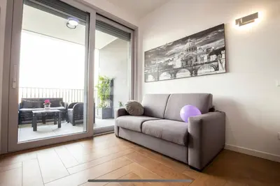 a living room with a couch and a sliding glass door at Stylish suite close by Trastevere and city life in Rome