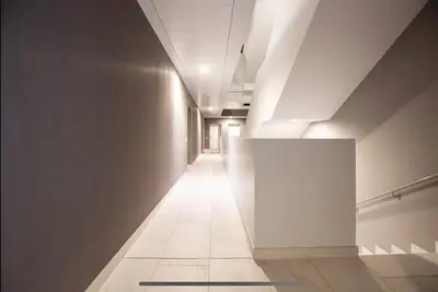 a hallway with a white wall and a tile floor at Stylish suite close by Trastevere and city life in Rome