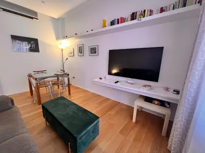 a living room with a table and a large screen tv at San Giovanni tourist accommodation in Rome