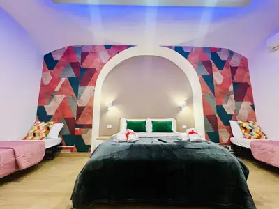 a bedroom with a large bed with a colorful wall at Luminosa House Roma Central Station in Rome