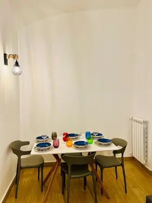 a table with four chairs and plates on it at Luminosa House Roma Central Station in Rome