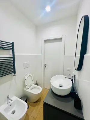 a white bathroom with a toilet and a sink at Luminosa House Roma Central Station in Rome