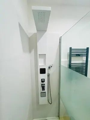 a walk in shower in a bathroom with a glass door at Luminosa House Roma Central Station in Rome