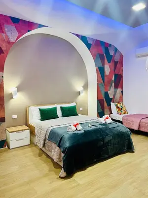 a bedroom with a bed and a colorful wall at Luminosa House Roma Central Station in Rome