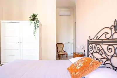 a bedroom with a bed with an orange pillow at Grandma Roma San Giovanni in Rome
