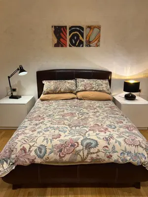 a bedroom with a bed with a floral bedspread at Giulio Cesare APT in Rome