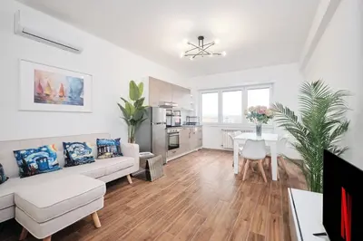 a living room with a white couch and a table at Gens Iulia 2 Min da Stazione Trastevere by Hôtea in Rome