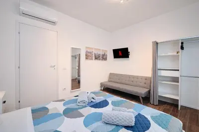 a living room with a bed and a couch at Gens Iulia 2 Min da Stazione Trastevere by Hôtea in Rome
