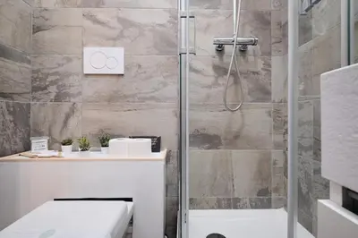 a bathroom with a shower with a toilet and a sink at Gens Iulia 2 Min da Stazione Trastevere by Hôtea in Rome