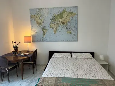 a bedroom with a bed and a table with a map on the wall at corte degli ulivi in roma in Rome